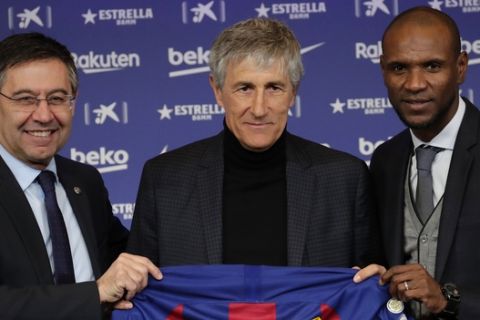 Soccer coach Quique Setien poses with FC Barcelona's President Josep Maria Bartomeu, left, and director of football Eric Abidal, right, while being officially introduced as the club's new coach at the Camp Nou stadium in Barcelona, Spain, Tuesday, Jan. 14, 2020. Barcelona made a rare coaching change midway through the season, replacing Ernesto Valverde with former Real Betis manager Quique Setien on Monday. (AP Photo/Emilio Morenatti)
