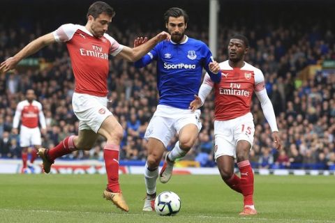 Everton's Andre Gomes, center, battles for the ball with Arsenal's Sokratis Papastathopoulos, left, and Ainsley Maitland-Niles during their English Premier League soccer match at Goodison Park, Liverpool, England, Sunday, April 7, 2019. (Peter Byrne/PA via AP)
