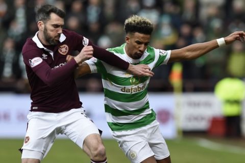 Hearts Michael Smith tackles Celtic's Scott Sinclair during their Scottish Premiership soccer match at Tynecastle Stadium in Edinburgh, Scotland, Sunday Dec. 17, 2017.  Celtics record 69-match unbeaten run in Scottish soccer ended with a surprise thrashing on Sunday, when they lost 4-0 to Hearts, for its first defeat in any domestic competition since May 2016.(Ian Rutherford/PA via AP)