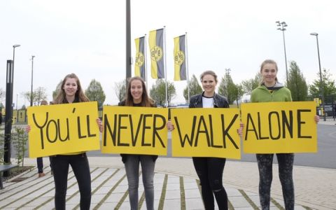 Dortmund supporters hold posters "You'll never walk alone" outside the training ground of Borussia Dortmund in Dortmund, Germany, Wednesday, April 12, 2017, one day after an explosion at the bus of the team prior to the Champions League quarterfinal soccer match between Borussia Dortmund and AS Monaco (AP Photo/Mike Corder)