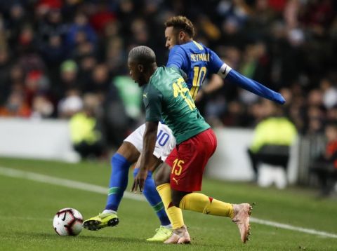 Brazil's Neymar and Cameroon's Jeando Fuchs, in front challenge for the ball during the International friendly soccer match between Brazil and Cameroon at MK Stadium in Milton Keynes, England, Tuesday, Nov. 20, 2018 . (AP Photo/Frank Augstein)