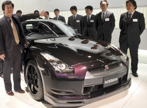 Kazutoshi Mizuno, chief vehicle engineer of Nissan Motor Co., introduces his sattf to journalists as they stand around a new Nissan GT-R after a press conference at Nissan head office in Tokyo, Thursday, Jan. 8, 2009. Nissan showed Thursday a 15 million yen (US$161,300) souped up version of its GT-R sportscar that the Japanese automaker said was still a bargain compared to European rivals. (AP Photo/Katsumi Kasahara)