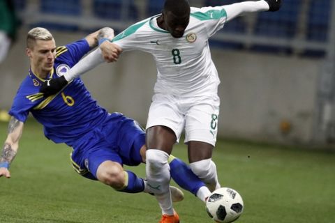 Senegal's Mbaye Niang, top, is tackled by Bosnia and Herzegovina Ognjen Vranjes during a friendly soccer match between Senegal and Bosnia and Herzegovina at the Oceane stadium in Le Havre, northern France, Tuesday, March 27, 2018. (AP Photo/Francois Mori)