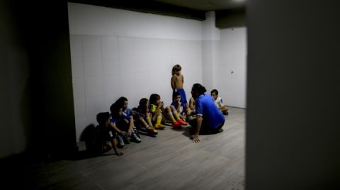 In this March 18, 2017 photo, coach Ariel Picallo talks to his team of 7-year-olds after they lost a game at the youth soccer academy Club Social Parque in a working class neighborhood of Buenos Aires, Argentina. At his youth soccer academy, about 150 children as young as 6 from all economic levels train together twice a week and compete on the weekends. (AP Photo/Natacha Pisarenko)