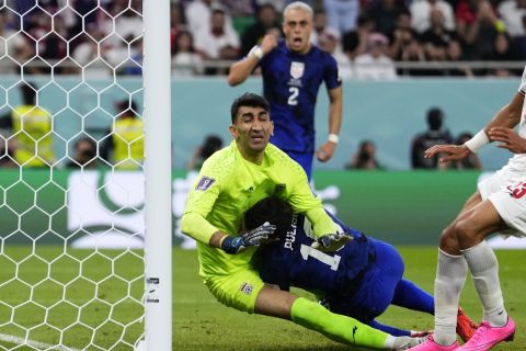 Christian Pulisic of the United States, right, collides with Iran's goalkeeper Alireza Beiranvand, left, after scoring his sides first goal during the World Cup group B soccer match between Iran and the United States at the Al Thumama Stadium in Doha, Qatar, Tuesday, Nov. 29, 2022. (AP Photo/Manu Fernandez)