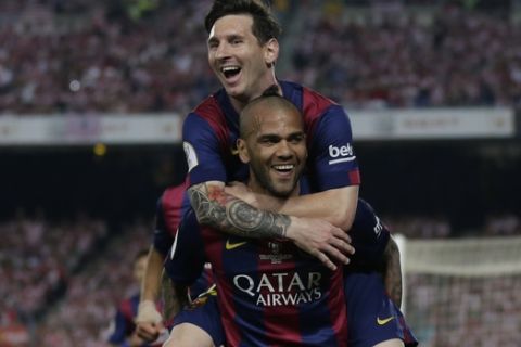 Barcelona's Lionel Messi, left, celebrates with Dani Alves after scoring his sides third goal during the final of the Copa del Rey soccer match between FC Barcelona and Athletic Bilbao at the Camp Nou stadium in Barcelona, Spain, Saturday, May 30, 2015. (AP Photo/Manu Fernandez)