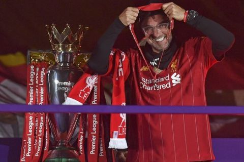 Liverpool's manager Jurgen Klopp puts on his winners medal following the English Premier League soccer match between Liverpool and Chelsea at Anfield Stadium in Liverpool, England, Wednesday, July 22, 2020. Liverpool are champions of the EPL for the season 2019-2020. The trophy is presented at the teams last home game of the season. Liverpool won the match against Chelsea 5-3. (Paul Ellis, Pool via AP)