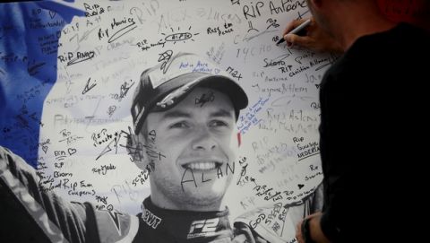 A man signs a remembrance board for Formula 2 driver Anthoine Hubert at the Belgian Formula One Grand Prix circuit in Spa-Francorchamps, Belgium, Sunday, Sept. 1, 2019. The 22-year-old Hubert died Saturday following an estimated 160 mph (257 kph) collision on Lap 2 at the high-speed Spa-Francorchamps track, which earlier Saturday saw qualifying for Sunday's Formula One race. (AP Photo/Francisco Seco)