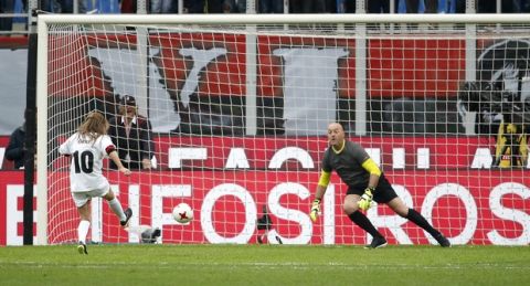 Geri Halliwell, left, kicks a penalty kick against former Liverpool goalkeeper Bruce Grobbelaar prior to the Serie A soccer match between AC Milan and Napoli at the San Siro stadium in Milan, Italy, Sunday, April 15, 2018. (AP Photo/Antonio Calanni)