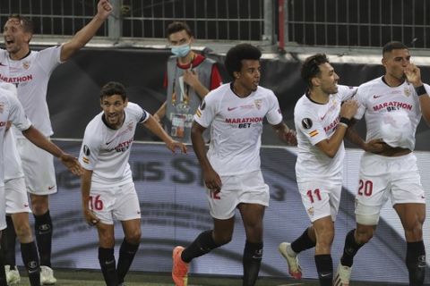 Sevilla's Diego Carlos, right, celebrates after scoring his side's third goal during the Europa League final soccer match between Sevilla and Inter Milan in Cologne, Germany, Friday, Aug. 21, 2020. (Friedemann Vogel/Pool via AP)