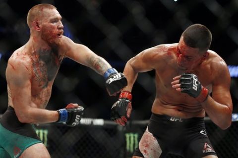 Conor McGregor fights Nate Diaz during their welterweight mixed martial arts bout at UFC 202 on Saturday, Aug. 20, 2016, in Las Vegas. McGregor won by split decision. (AP Photo/Isaac Brekken)