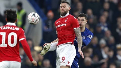 Chelsea's Antonio Ruediger, right, fights for the ball with Nottingham Forest's Daryl Murphy during the English FA Cup third round soccer match between Chelsea and Nottingham Forest at Stamford Bridge in London, Saturday, Jan. 5, 2019. (AP Photo/Alastair Grant)