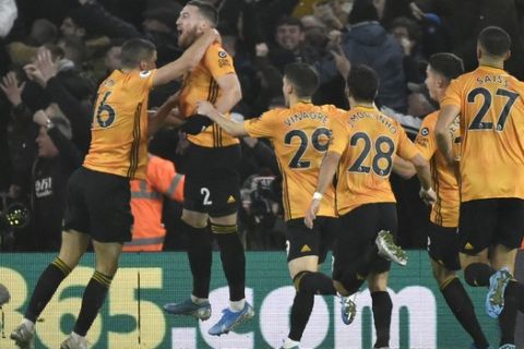 Wolverhampton Wanderers' Matt Doherty, jumps in celebrations with his teammates after scoring his side's third goal during the English Premier League soccer match between Wolverhampton Wanderers and Manchester City at the Molineux Stadium in Wolverhampton, England, Friday, Dec. 27, 2019. (AP Photo/Rui Vieira)