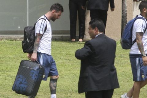 Argentina's Lionel Messi, left, walks to a waiting bus in Santa Cruz de la Sierra, Bolivia, Tuesday, March 28, 2017. Messi has been banned from Argentina's next four World Cup qualifiers, starting with Tuesday's game in Bolivia, for "having directed insulting words at an assistant referee" during a home qualifier against Chile last Thursday, FIFA said hours before kickoff in La Paz. (AP Photo)
