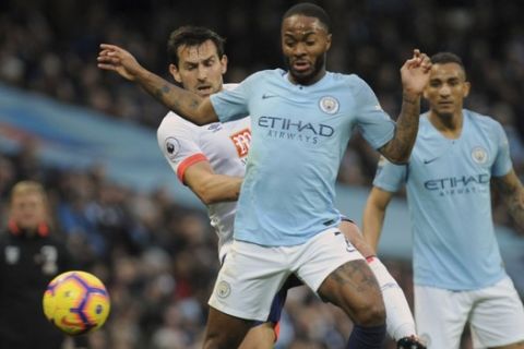 Manchester City's Raheem Sterling, front, duels for the ball with Bournemouth's Charlie Daniels during the English Premier League soccer match between Manchester City and Bournemouth at Etihad stadium in Manchester, England, Saturday, Dec. 1, 2018. (AP Photo/Rui Vieira)
