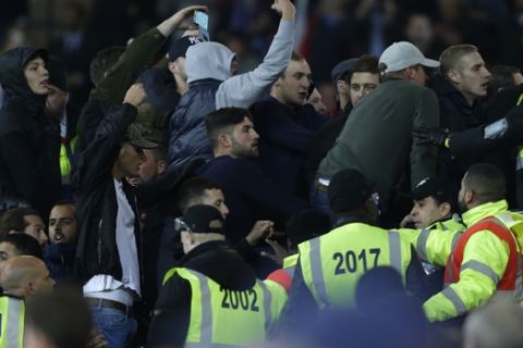 Rival supporters taunt each other and clash with stewards during the English League Cup soccer match between West Ham United and Chelsea at the London stadium in London in London, Wednesday, Oct. 26, 2016. West Ham defeated Chelsea by 2-1. (AP Photo/Alastair Grant)