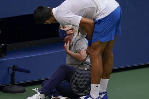 Novak Djokovic, of Serbia, checks a linesman after hitting her with a ball in reaction to losing a point to Pablo Carreno Busta, of Spain, during the fourth round of the US Open tennis championships, Sunday, Sept. 6, 2020, in New York. Djokovic defaulted the match. (AP Photo/Seth Wenig)