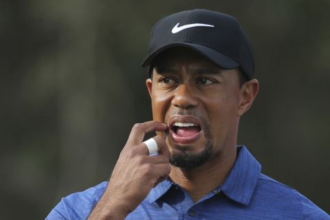 FILE - In this Feb. 2, 2017, file photo, Tiger Woods reacts on the 11th hole during the first round of the Dubai Desert Classic golf tournament in Dubai, United Arab Emirates. Woods wont play in the Masters for the third time in the last four years, announcing Friday night, March 31, 2017, on his website that rehabilitation on his back didnt allow him enough time to get ready.  (AP Photo/Kamran Jebreili, File)