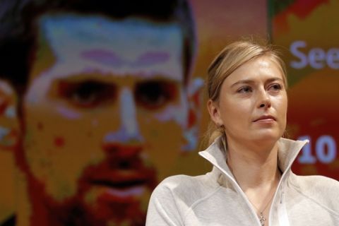 Defending champion Russia's Maria Sharapova attends the draw for the French Tennis Open, with a portrait of Serbia's Novak Djokovic on a screen behind,  at the Roland Garros stadium, Friday, May 22, 2015 in Paris. The French Open starts Sunday. (AP Photo/Francois Mori)