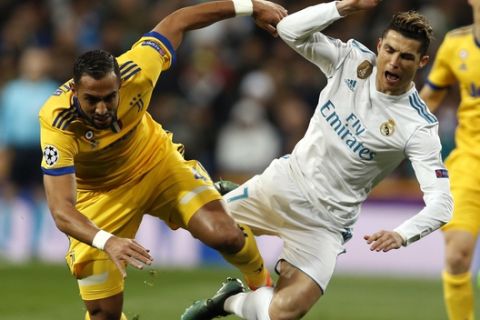 Real Madrid's Cristiano Ronaldo is tackled by Juventus' Medhi Benatia during a Champions League quarter final second leg soccer match between Real Madrid and Juventus at the Santiago Bernabeu stadium in Madrid, Wednesday, April 11, 2018. (AP Photo/Francisco Seco)