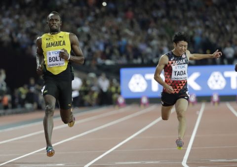 Jamaica's Usain Bolt, left, crosses the line ahead of Japan's Shuhei Tada to win his Men's 100m first round heat during the World Athletics Championships in London, Friday, Aug. 4, 2017. (AP Photo/David J. Phillip)