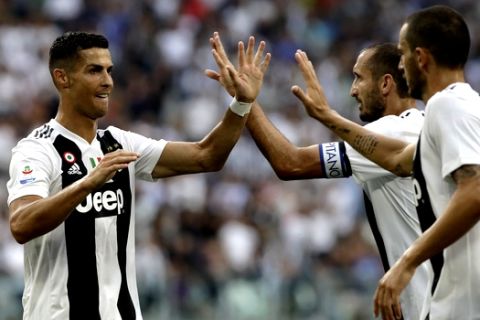 Juventus' Cristiano Ronaldo, left, celebrates with Juventus' Giorgio Chiellini, second right after their teammate Juventus' Miralem Pjanic scored the opening goal of the game during the Serie A soccer match between Juventus and Lazio at the Allianz Stadium in Turin, Italy, Saturday, Aug. 25, 2018. (AP Photo/Luca Bruno)