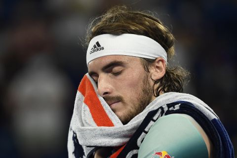 Stefanos Tsitsipas of Greece wipes the sweat from his face during his quarterfinal match against Jannik Sinner of Italy at the Australian Open tennis championships in Melbourne, Australia, Wednesday, Jan. 26, 2022. (AP Photo/Andy Brownbill)