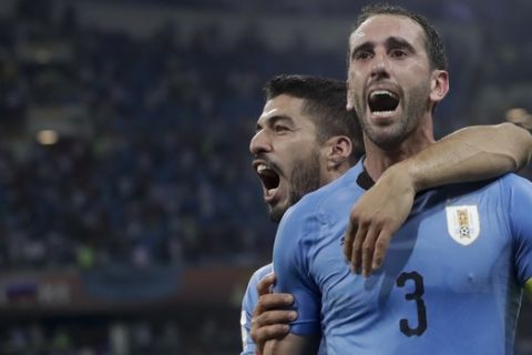 Uruguay's Luis Suarez, left, and Diego Godin celebrate after the round of 16 match between Uruguay and Portugal at the 2018 soccer World Cup at the Fisht Stadium in Sochi, Russia, Saturday, June 30, 2018. (AP Photo/Andre Penner)