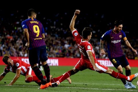 FC Barcelona's Lionel Messi, right, duels for the ball against Girona's Pedro Alcala, second right, during the Spanish La Liga soccer match between FC Barcelona and Girona at the Camp Nou stadium in Barcelona, Spain, Sunday, Sept. 23, 2018. (AP Photo/Manu Fernandez)
