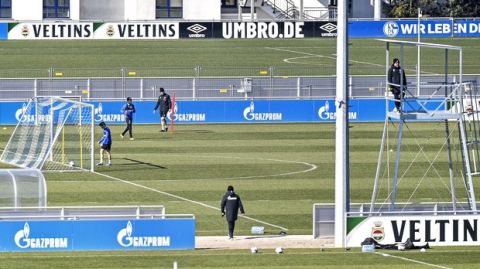 Due to the coronavirus outbreak at most two players of the German first division, Bundesliga, soccer club Schalke 04 exercise together to keep distance during the training on club's the training ground in Gelsenkirchen, Germany, Tuesday, April 1, 2020. The German Football League (DFL) announced all matches will be suspended until at least 30th April due to the ongoing coronavirus pandemic. The new coronavirus causes mild or moderate symptoms for most people, but for some, especially older adults and people with existing health problems, it can cause more severe illness or death. (AP Photo/Martin Meissner)