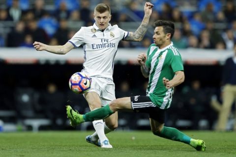 Real Madrid's Toni Kroos, left, tussles for the ball with Real Betis' Alin Tosca during a Spanish La Liga soccer match between Real Madrid and Real Betis at the Santiago Bernabeu stadium in Madrid, Sunday, March 12, 2017. (AP Photo/Francisco Seco)