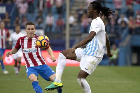 Malaga's Burkina Faso defender Bakary Kone (R) vies with Atletico Madrid's French forward Kevin Gameiro during the Spanish league football match between Club Atletico de Madrid and Malaga CF at the Vicente Calderon stadium in Madrid on October 29, 2016. / AFP PHOTO / CURTO DE LA TORRE