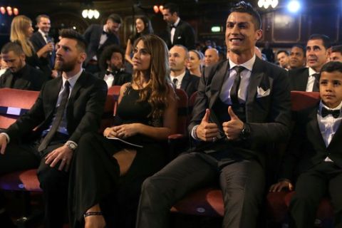 FILE - In this Monday, Oct. 23, 2017 file photo, Portuguese soccer player Christiano Ronaldo, second from right, and son Cristiano Ronaldo Jr., right, sit beside Argentinian soccer player Lionel Messi, left, and wife Antonella during the The Best FIFA 2017 Awards at the Palladium Theatre in London. Cristiano Ronaldo and Lionel Messi put up impressive numbers, in life and on the field, going into a fourth World Cup for each. So much has happened for football's standout stars since the 2014 tournament left both still lacking the game's most coveted prize. (AP Photo/Alastair Grant, File)