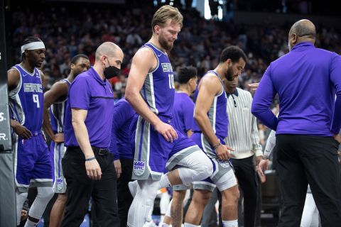 Sacramento Kings forward Domantas Sabonis (10) flexes his knee after injuring himself in the second half of an NBA basketball game against the Phoenix Suns in Sacramento, Calif., Sunday, March 20, 2022.  The Suns won 127-124.(AP Photo/José Luis Villegas)