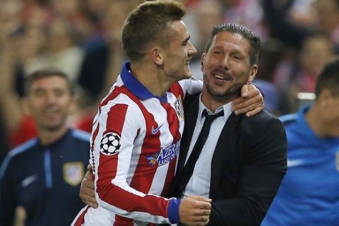 Atletico's Antoine Griezmann, left, celebrates with his coach Diego Simeone after scoring during the Group A Champions League soccer match between Atletico de Madrid and Malmo at the Vicente Calderon stadium in Madrid, Spain, Wednesday, Oct. 22, 2014. (AP Photo/Andres Kudacki)