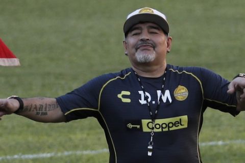 Former soccer great Diego Maradona dances on the pitch at the Dorados de Sinaloa soccer club stadium, after Maradona was presented as the new manager of the Dorados in Culiacan, Mexico, Monday, Sept. 10, 2018. Maradona, whose public battles with cocaine made him soccer's poster child for the perils of substance abuse, is setting up camp in Mexico's drug cartel heartland as the new coach of a second-tier team. (AP Photo/Marco Ugarte)