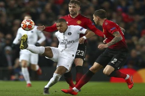 Paris Saint Germain's Kylian Mbappe, controls the ball under pressure from Manchester United's Luke Shaw, centre and Manchester United's Victor Linelof, right, during the Champions League round of 16 soccer match between Manchester United and Paris Saint Germain at Old Trafford stadium in Manchester, England, Tuesday, Feb. 12,2019.(AP Photo/Dave Thompson)