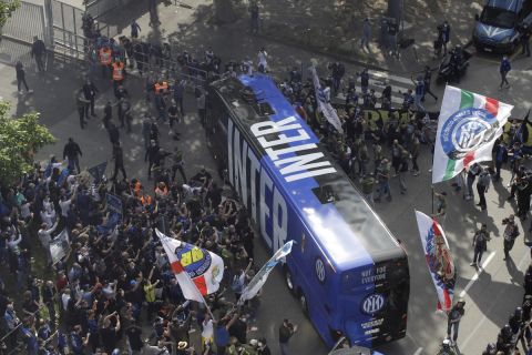 Inter Milan fans celebrate and shout slogans celebrating Inter Milan's Serie A title, as the team's bus arrives prior to the start of a Serie A soccer match between Inter Milan and Sampdoria, at Milan's San Siro stadium, Saturday, May 8, 2021. (AP Photo/Luca Bruno)