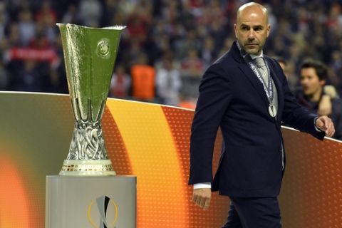 Ajax coach Peter Bosz walks past the trophy at the end of the soccer Europa League final between Ajax Amsterdam and Manchester United at the Friends Arena in Stockholm, Sweden, Wednesday, May 24, 2017. United won 2-0. (AP Photo/Martin Meissner)