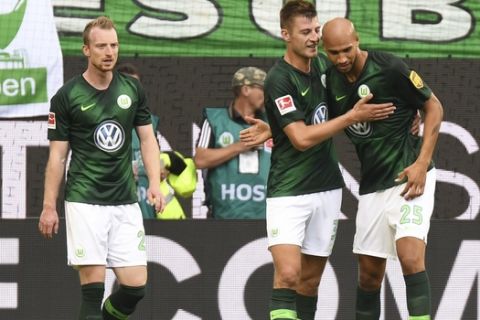 Wolfsburg's John Anthony Brooks, right, celebrates with team mates Robin Knoche, center, and Maximilian Arnold, left, his opening goal during the German Bundesliga soccer match between VfL Wolfsburg and FC Schalke 04 in Wolfsburg, Germany, Saturday, Aug. 25, 2018. (Peter Steffen/dpa via AP)/dpa via AP)