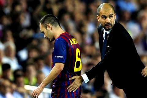 FC Barcelona's Andres Iniesta, left, walks to the bench after been injured, accompanied  his coach Pep Guardiola,  during a Champions league soccer match against AC Milan at the Nou Camp stadium in Barcelona, Spain, Tuesday, Sept. 13, 2011. (AP Photo/Manu Fernandez)
