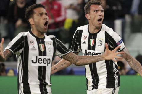 Juventus' Mario Mandzukic, right, celebrates after scoring his side's opening goal besides team mate Dani Alves during the Champions League semi final second leg soccer match between Juventus and Monaco in Turin, Italy, Tuesday, May 9, 2017. (AP Photo/Luca Bruno)