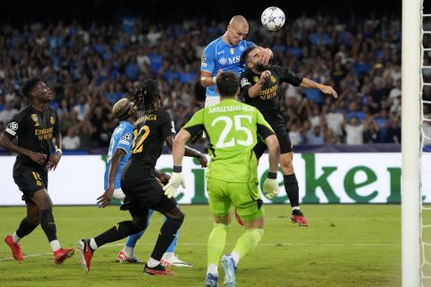 Napoli's Leo Ostigard, 2nd right, scores with a header his sides first goal during the Champions League group C soccer match between Napoli and Real Madrid at the Diego Armando Maradona stadium in Naples, Italy, Tuesday, Oct. 3, 2023. (AP Photo/Alessandra Tarantino)
