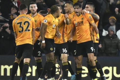 Wolverhampton Wanderers' Raul Jimenez, right, celebrates with his teammates after scoring his side's third goal during the English Premier League soccer match between Wolverhampton Wanderers and Manchester City at the Molineux Stadium in Wolverhampton, England, Friday, Dec. 27, 2019. (AP Photo/Rui Vieira)