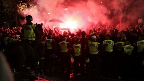 Eintracht Frankfurt fans, who are not allowed in the stadium after crowd trouble at their game against Vitoria Guimaraes in October, let off flares as their team's bus with the players arrives for the Europa League Group F soccer match between Arsenal and Eintracht Frankfurt at the Emirates Stadium, in London, Thursday, Nov. 28, 2019. (AP Photo/Matt Dunham)