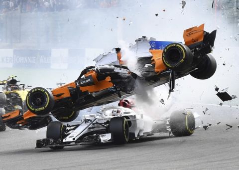 Mclaren driver Fernando Alonso of Spain, top, goes over the top of Sauber driver Charles Leclerc of Monaco as they are involved in a crash at the start of the Belgian Formula One Grand Prix in Spa-Francorchamps, Belgium, Sunday, Aug. 26, 2018. (AP Photo/Geert Vanden Wijngaert)