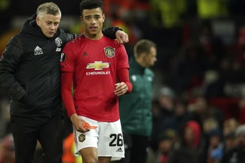 Manchester United's manager Ole Gunnar Solskjaer, left, and Manchester United's Mason Greenwood walk on the pitch at the end of the round of 32 second leg Europa League soccer match between Manchester United and Brugge at Old Trafford in Manchester, England, Thursday, Feb. 27, 2020. (AP Photo/Dave Thompson)