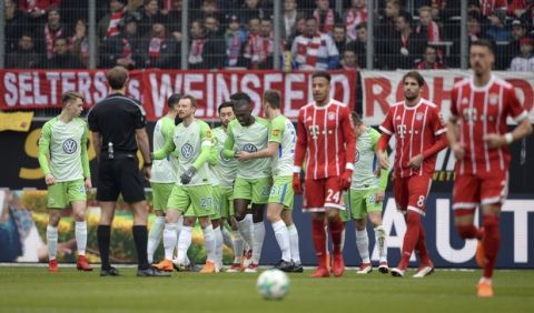 Wolfsburg's players, left,celebrate their opening goal  during the German Bundesliga soccer match between VfL Wolfsburg and Bayern Munich, in Wolfsburg, northern Germany, Saturday, Feb. 17, 2018. (Swen Pfoertner/dpa via AP)
