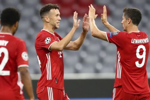 Bayern's Ivan Perisic, centre, is congratulated by teammate Robert Lewandowski after scoring his team's second goal during the Champions League round of 16 second leg soccer match between Bayern Munich and Chelsea at Allianz Arena in Munich, Germany, Saturday, Aug. 8, 2020. (AP Photo/Matthias Schrader)