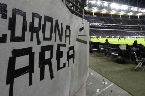 FILE - In this Thursday, March 12, 2020 file photo shows a sign taped by Eintracht fans on a wall of the stadium during a Europa League round of 16, 1st leg soccer match between Eintracht Frankfurt and FC Basel in Frankfurt, Germany. All Champions League and Europa League games were postponed by UEFA on Friday March 13, 2020 because of the coronavirus outbreak. For most people, the new coronavirus causes only mild or moderate symptoms, such as fever and cough. For some, especially older adults and people with existing health problems, it can cause more severe illness, including pneumonia. (AP Photo/Michael Probst)